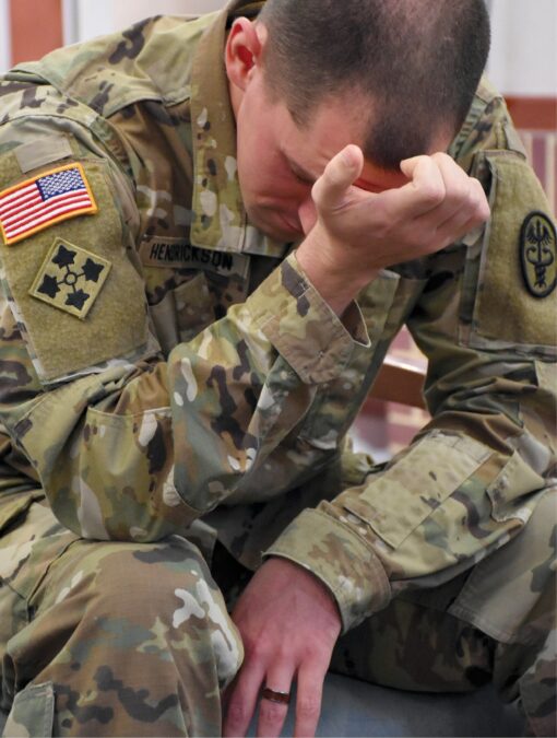 Stressed person sitting with head in hand